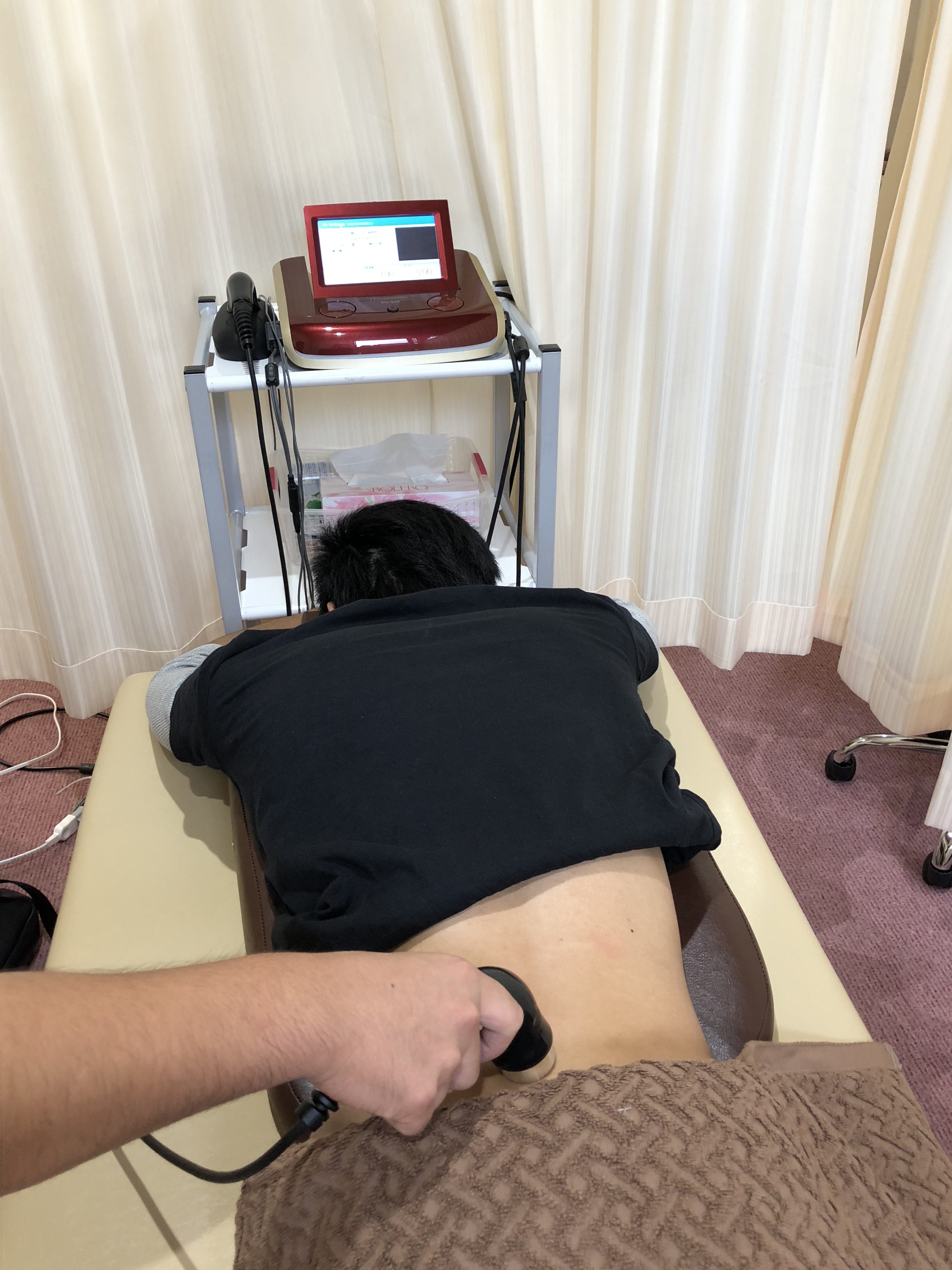 神戸三田やわら整骨院で坐骨神経痛の症状をハイボルテージを使用し施術している様子